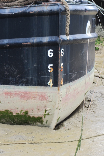 there is a boat sitting on the beach with numbers