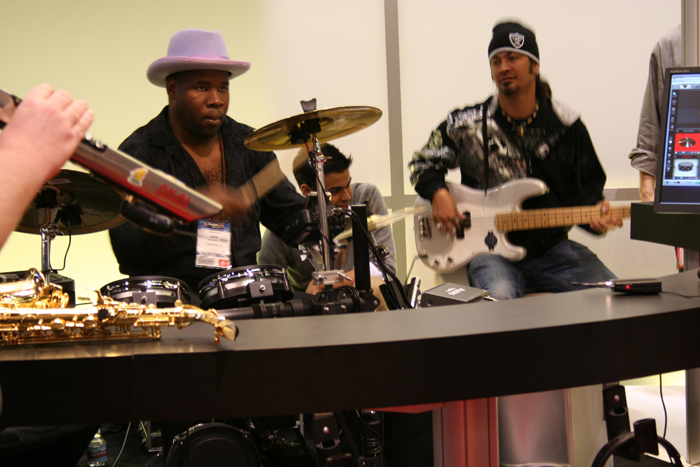 several men sitting around a desk with guitars and instruments