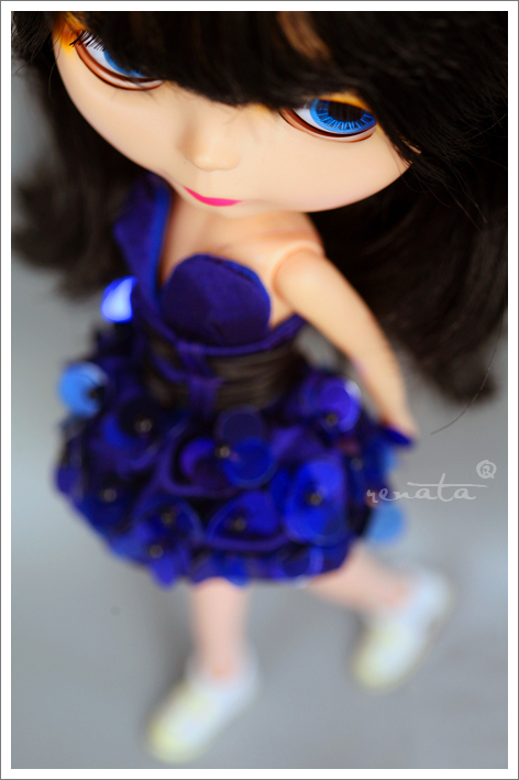a doll wearing a blue dress with flowers on it