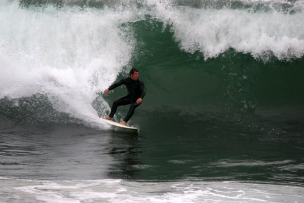a man is riding on his surf board on a wave
