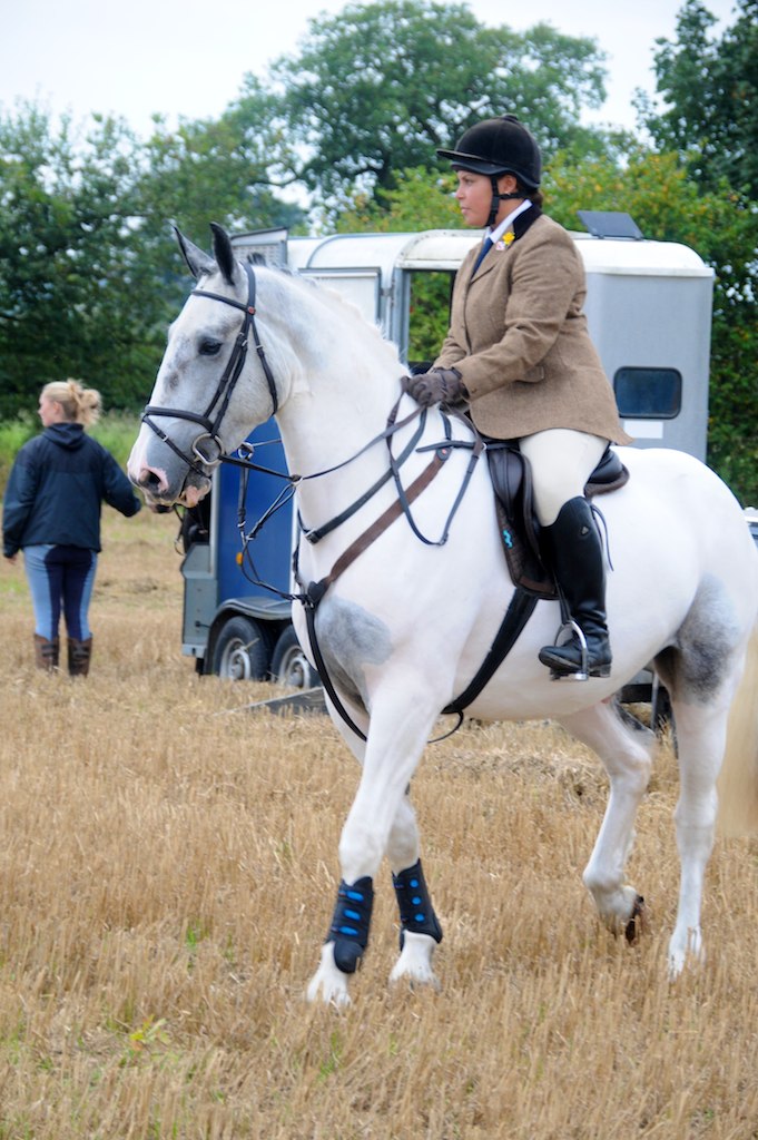 a woman riding on the back of a white horse