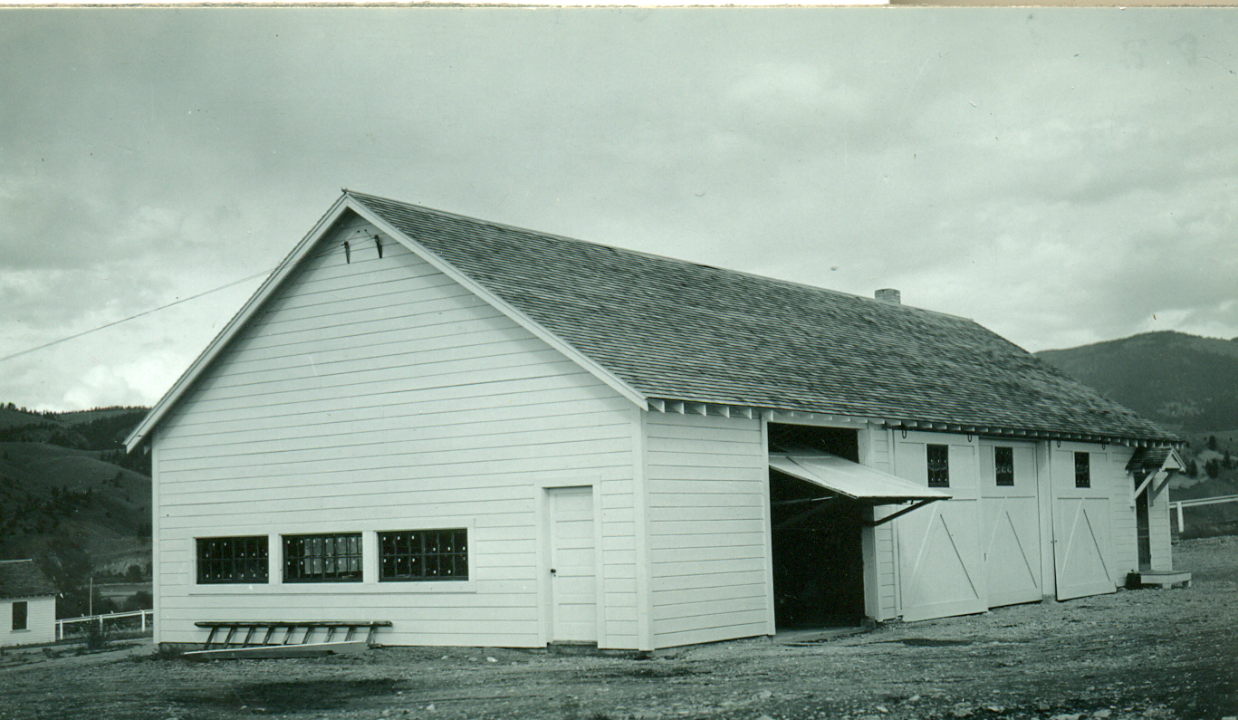 an old black and white po shows a barn with two garages