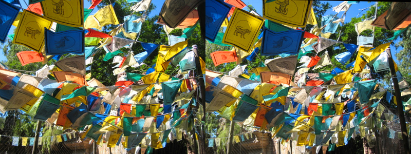 many colorful banners hanging on a wooden fence