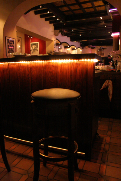 a dimly lit bar and a black stool