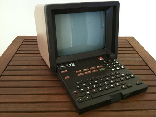 a very old portable laptop computer sitting on a wood table