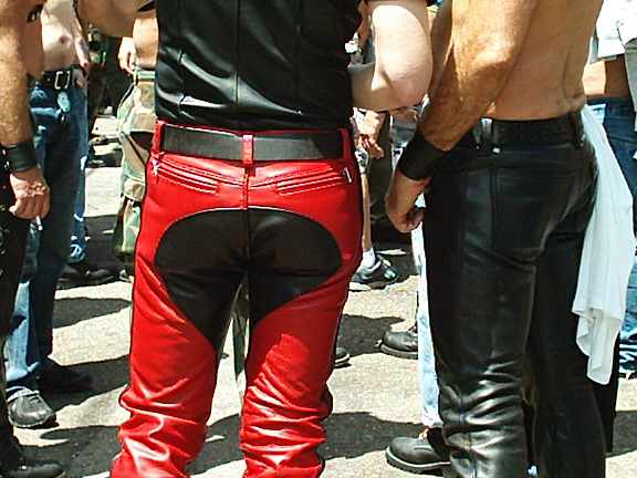 a person with black leather pants is standing in front of some other people