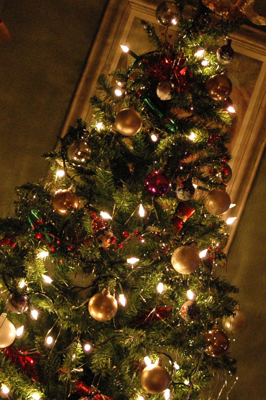 the top part of a christmas tree with garland and lights