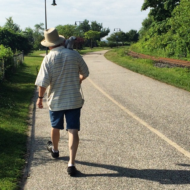 man in hat walking down the side walk