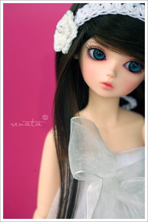 a doll wearing a white dress with large blue eyes