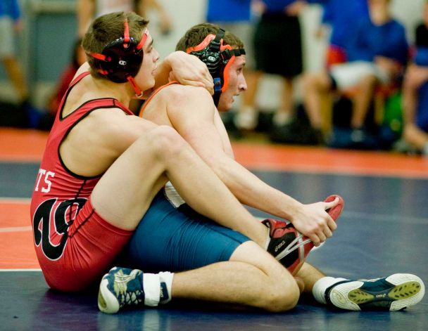 a wrestling match with two wrestlers sitting on the ground