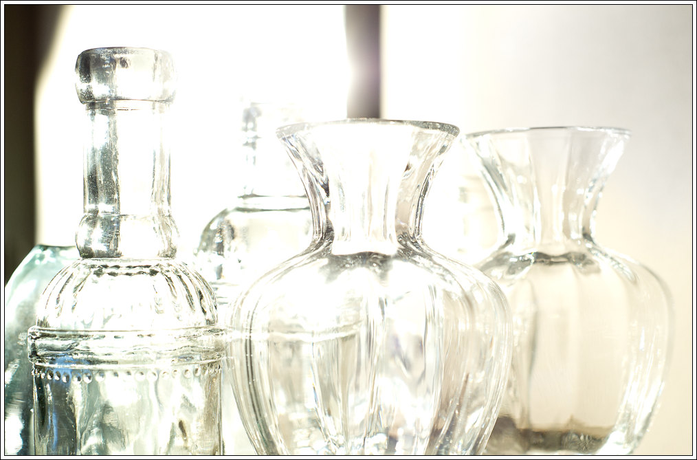 four clear vases are placed neatly on the counter