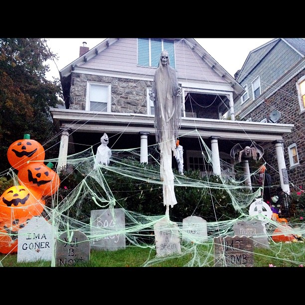 a decorated front lawn with halloween decorations and trees