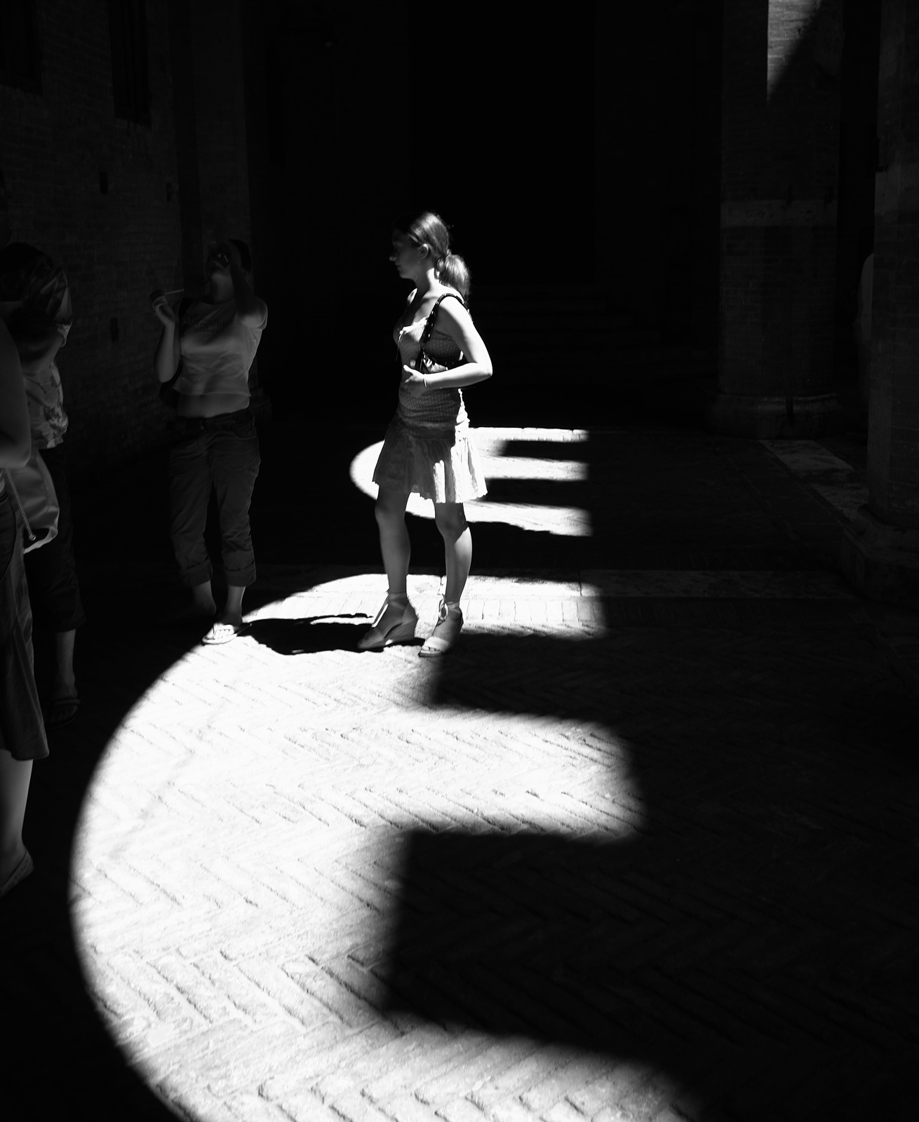 a woman is standing on a sidewalk in the dark