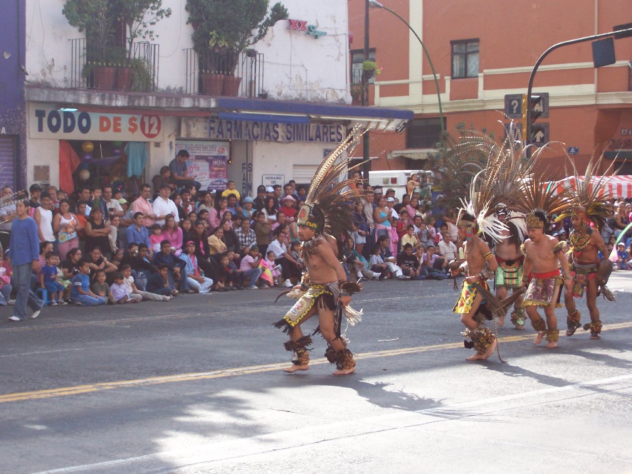 a group of dancers walking down the street at a parade