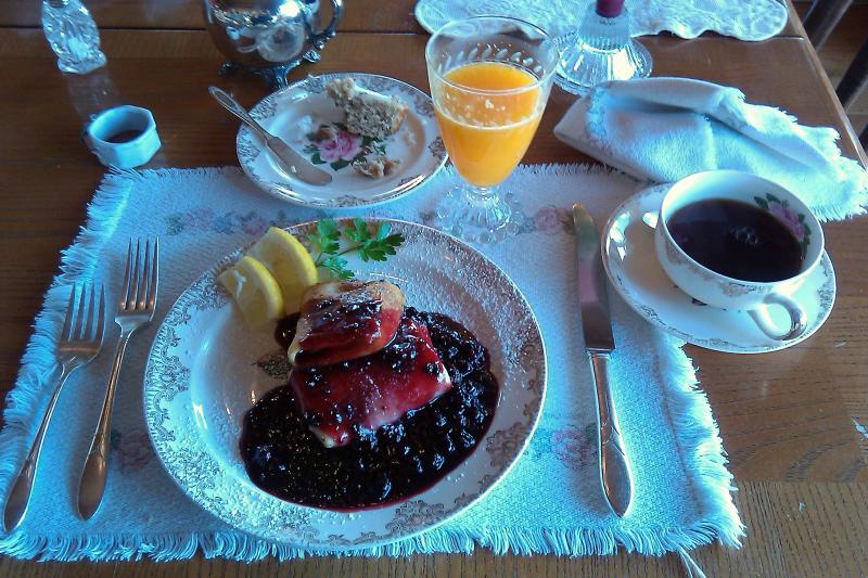 the table is filled with some food, utensils and cups