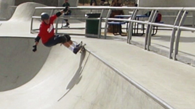 a person in red shirt skating on ramps