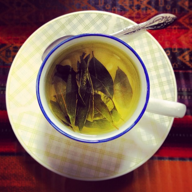 a cup of green tea with green leaves