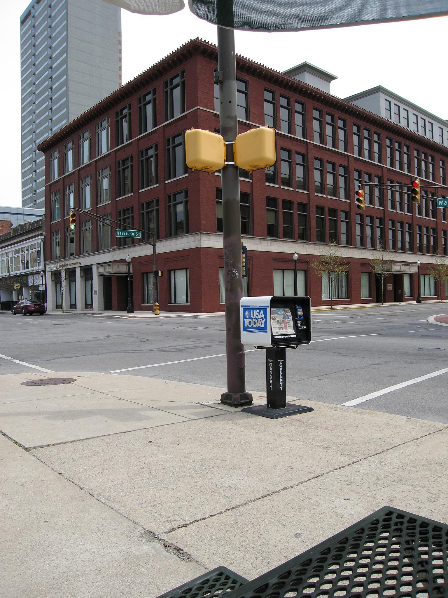 an empty street has a stop light and a brick building