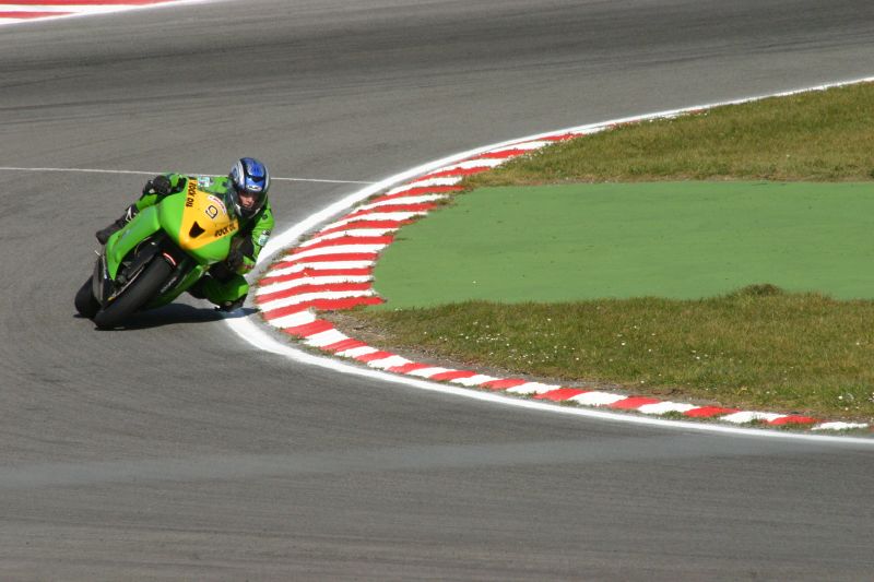 a motorcycle rider turning a corner on the race track