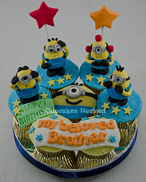 a cake with cupcakes and minion birthday candles