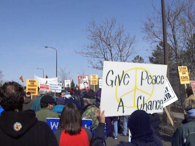 group of people holding a sign that says give peace a chance