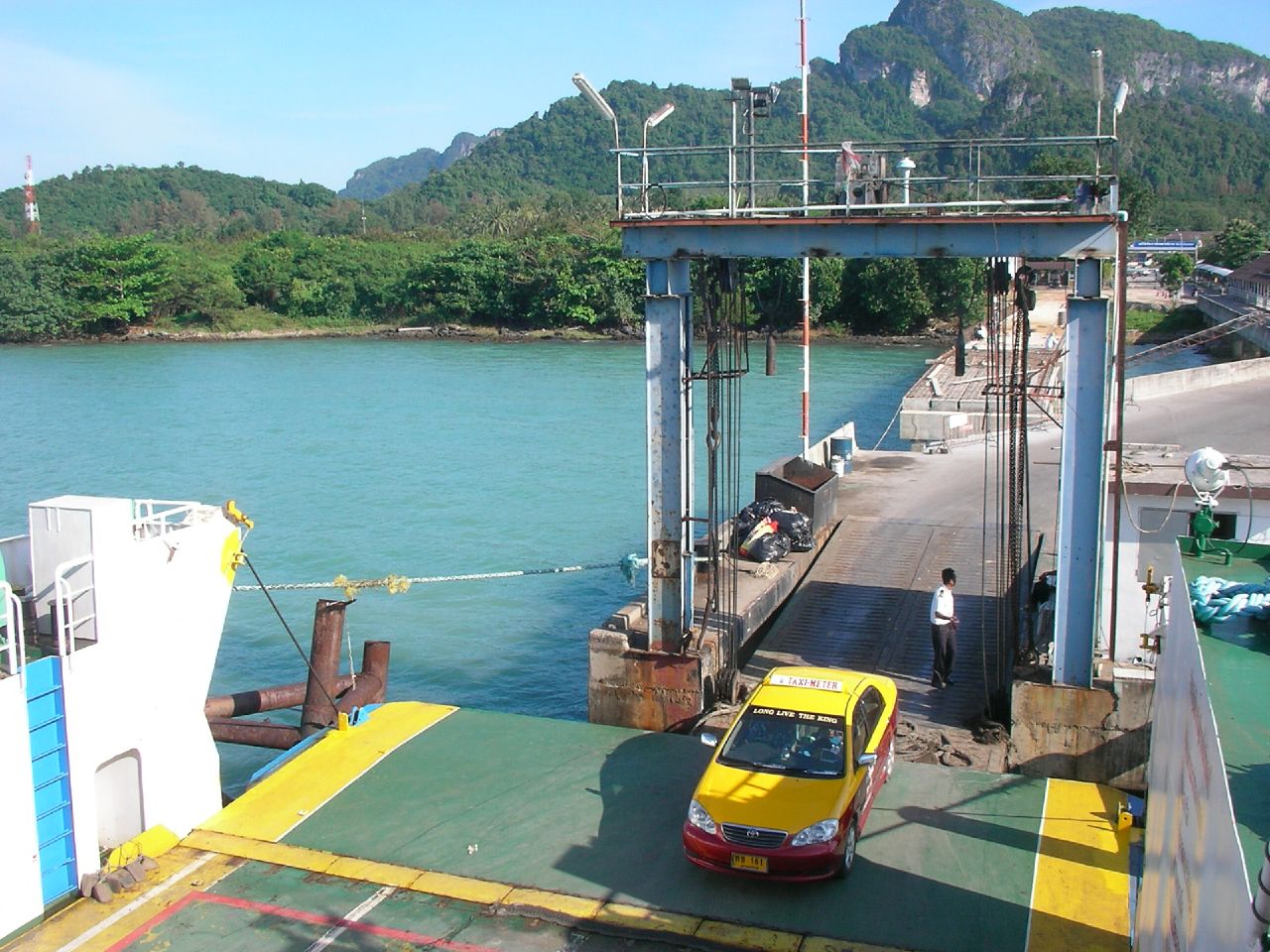 yellow car sitting at a ferry with another car next to it