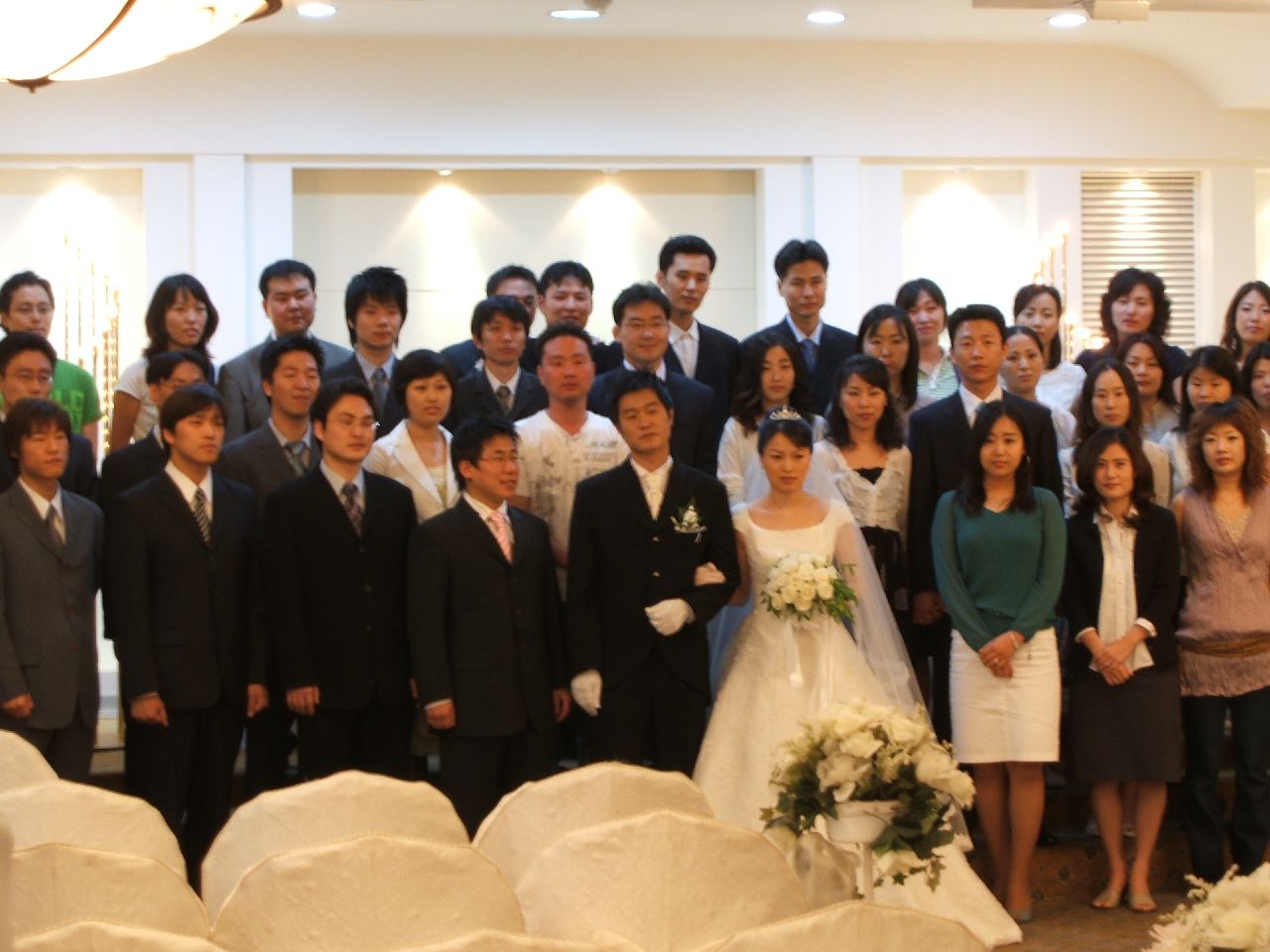 wedding group posing for a picture in a banquet hall