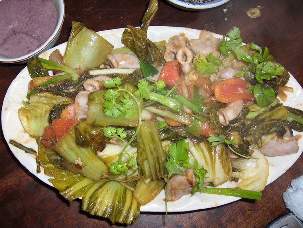 a plate topped with green vegetables and sliced artichokes