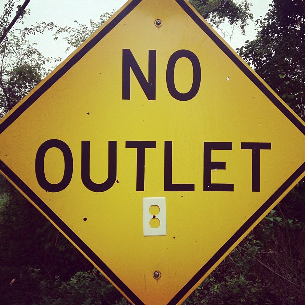 there is a yellow street sign that says no outlet