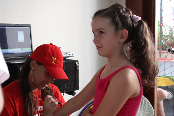 a woman in a red cap holding a childs hand