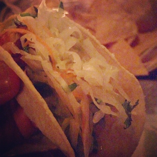 a close up of a person holding two tacos