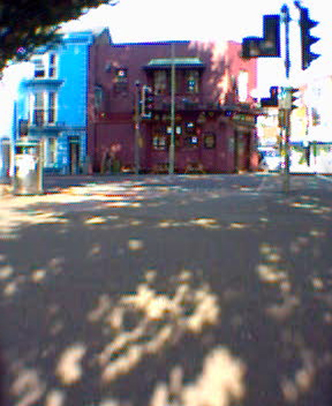 a view from across the street looking at an older building and trees