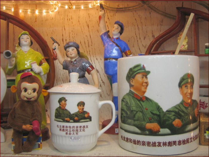 two mugs with cartoon images on them next to figurines