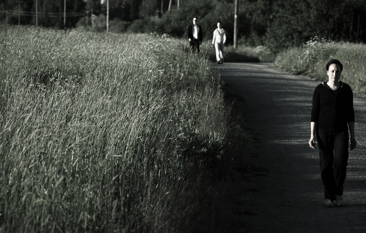 a woman walks down the street near grass