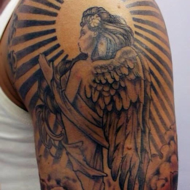 a tattoo on a man is showing it is angel with cross