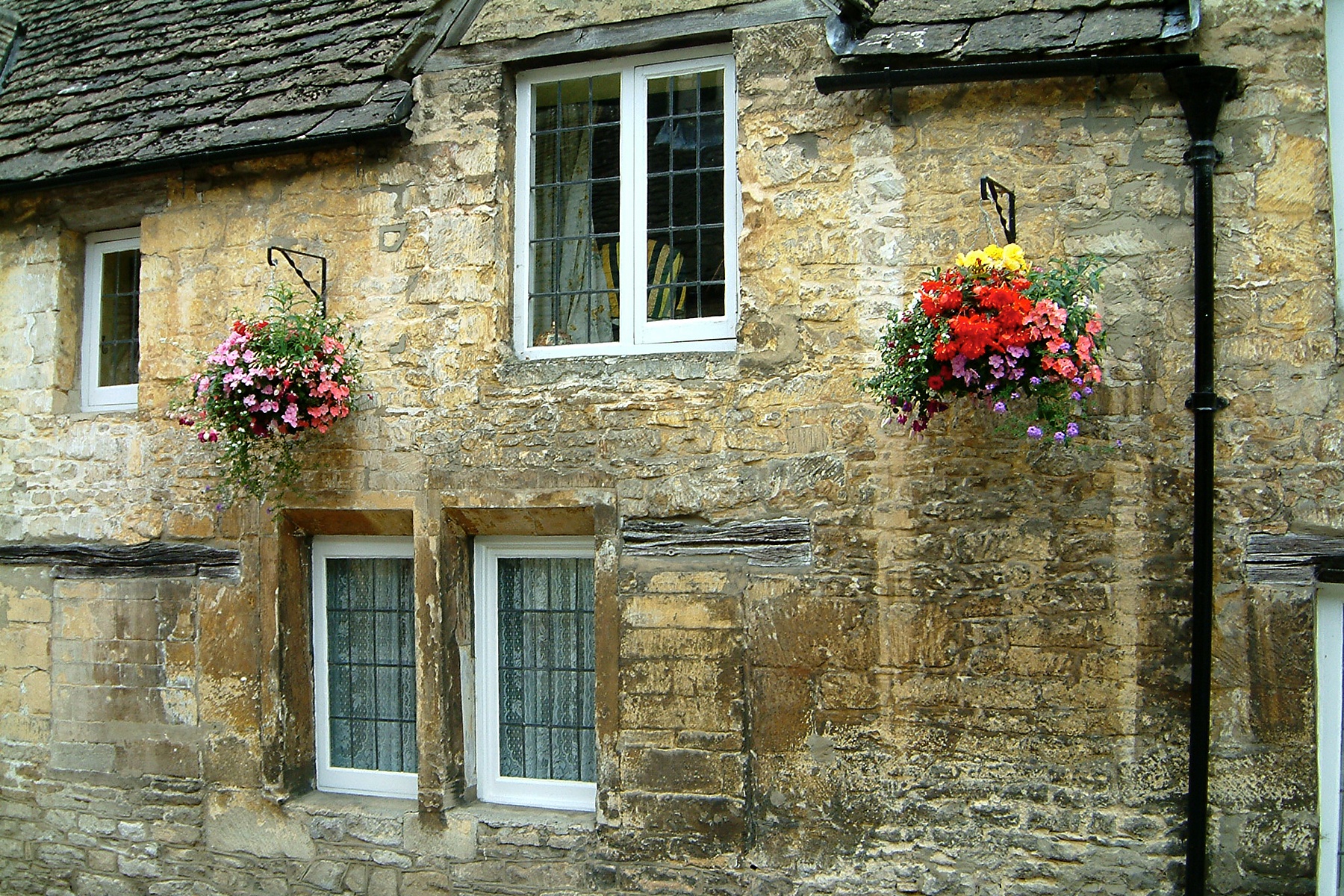 flowers hanging from the windows of a building