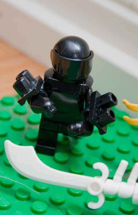 a lego man is on a green surface