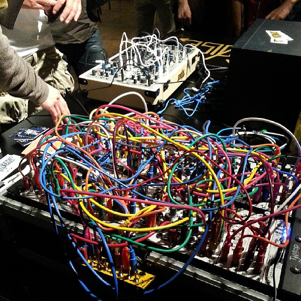 several people are around assorted electronic wiring