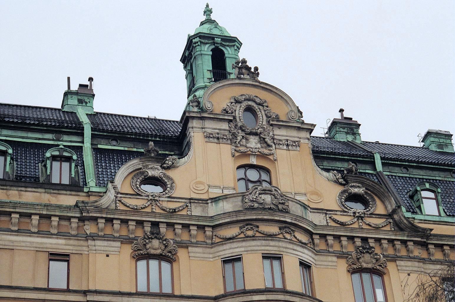 an old brown and green building with clock on top