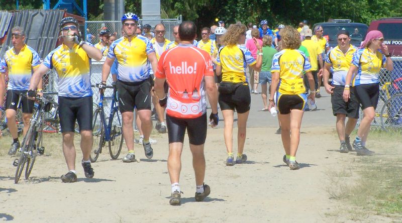 a group of bicyclists wearing yellow vests, bicycles and hats