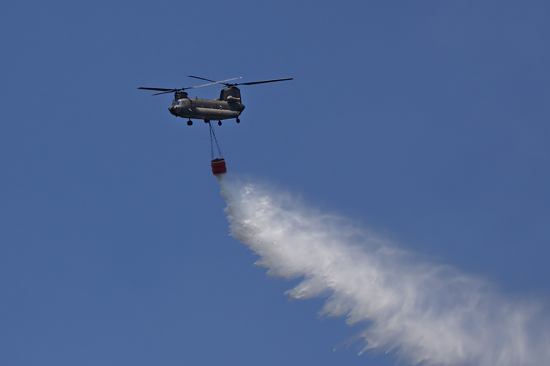 a helicopter flying through the sky with smoke coming from it