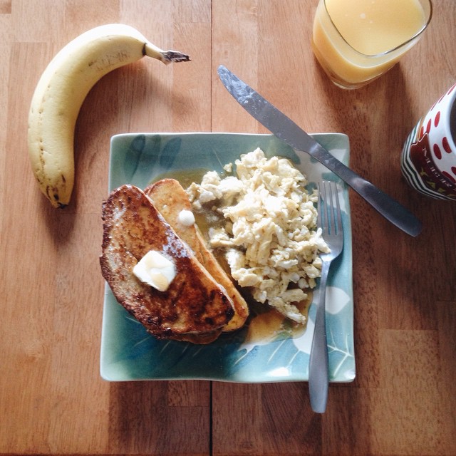 a plate with some french toast, eggs and a banana on it