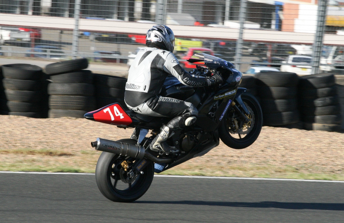 man on motorcycle performing stunts in a race