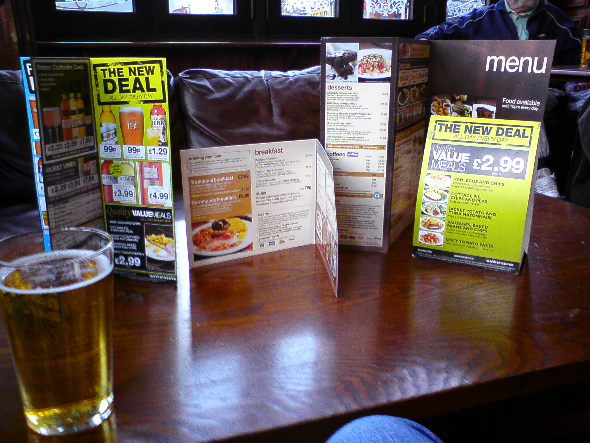 a close up of a menu, a glass of beer and a sign