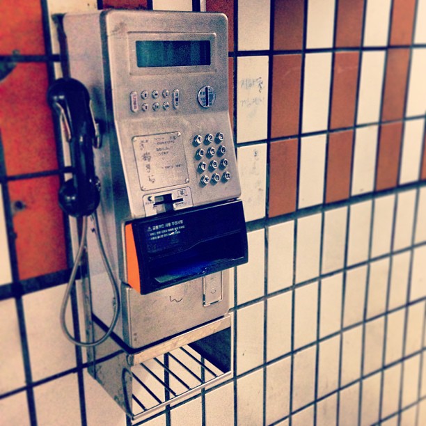 an old payphone hanging on a wall