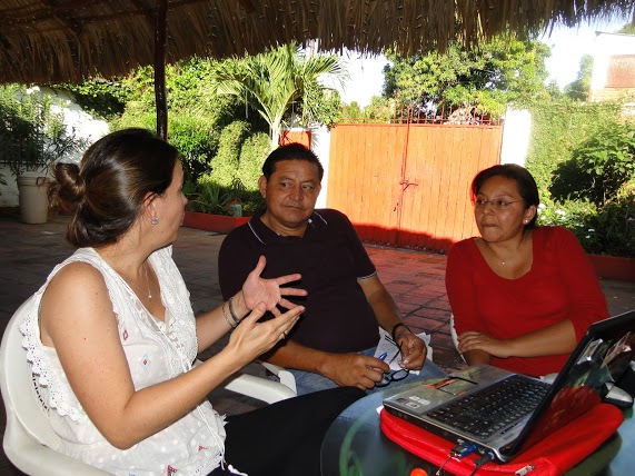 three people sitting around a table having a discussion
