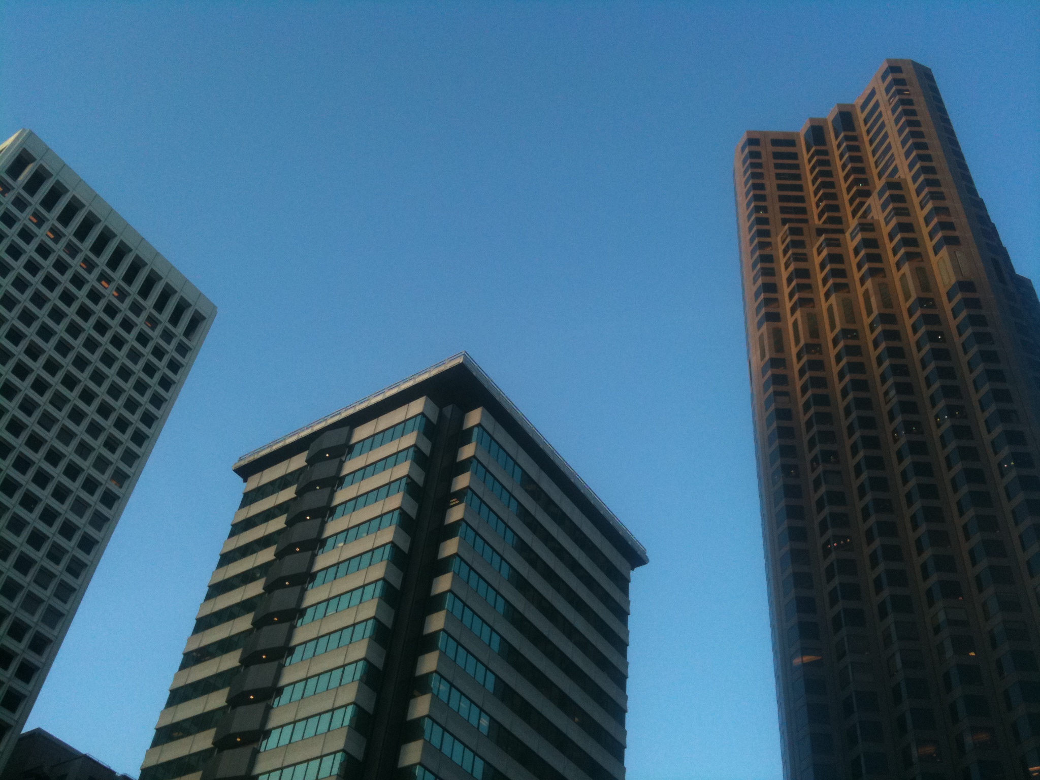 a cityscape of skyscrs against the blue sky