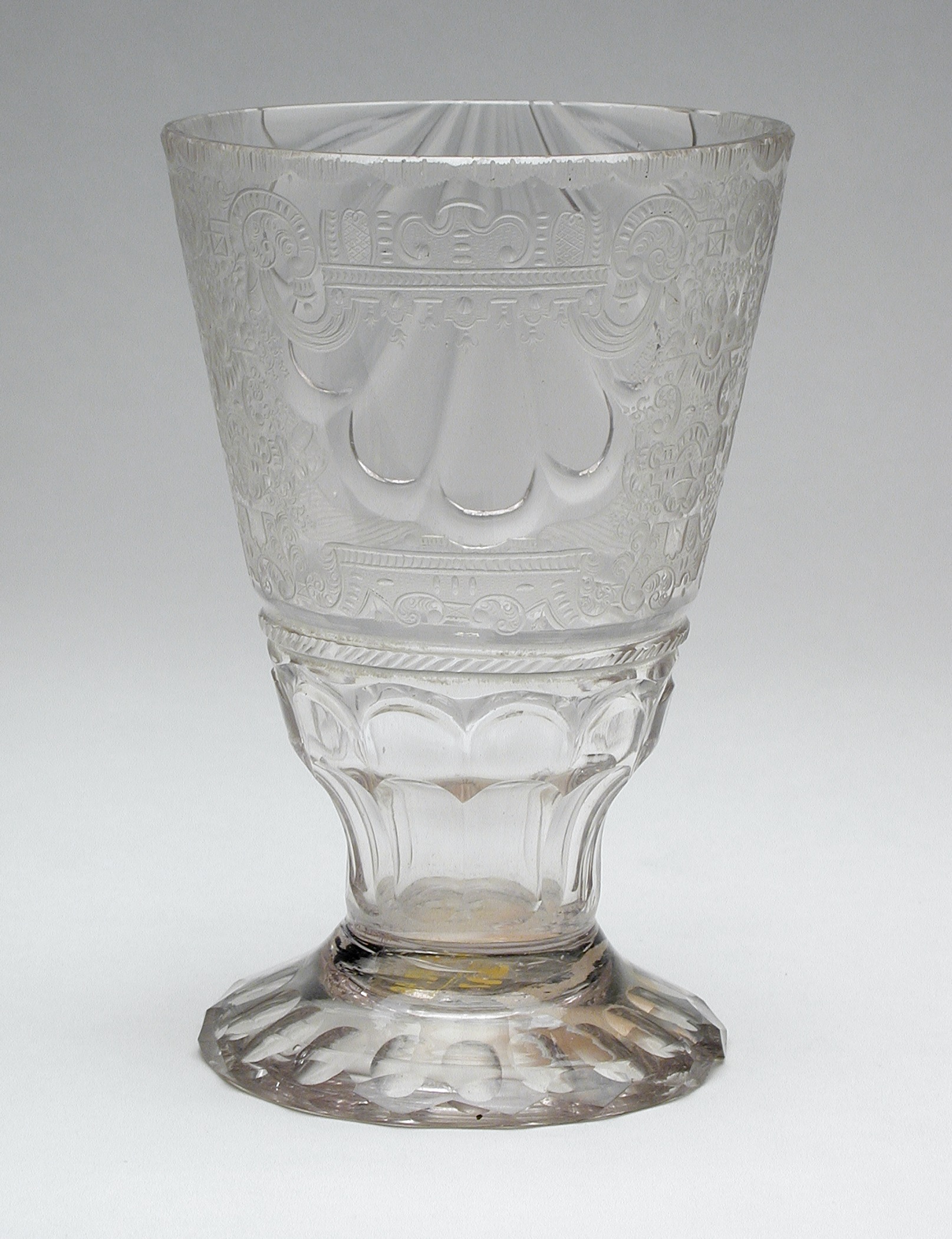an antique glass cup sitting on a table