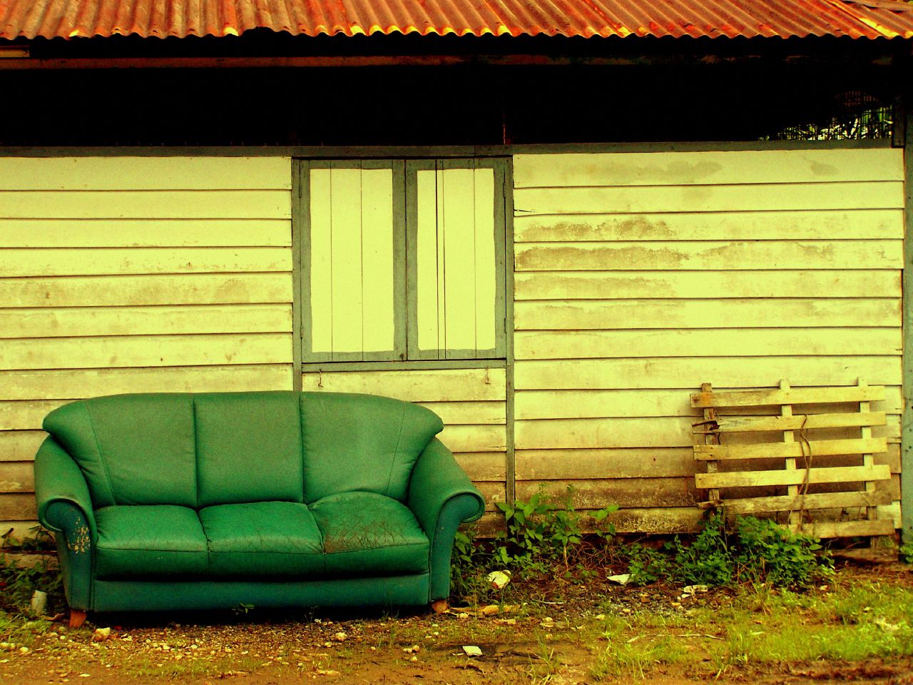 the house has an old green couch in front