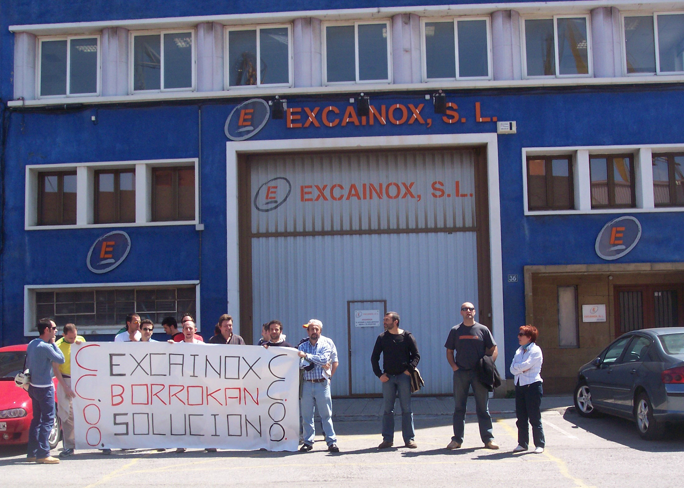several people stand in front of a blue building